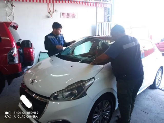 Equipo de JUCAR instalando un parabrisas en su taller de Peñalolén